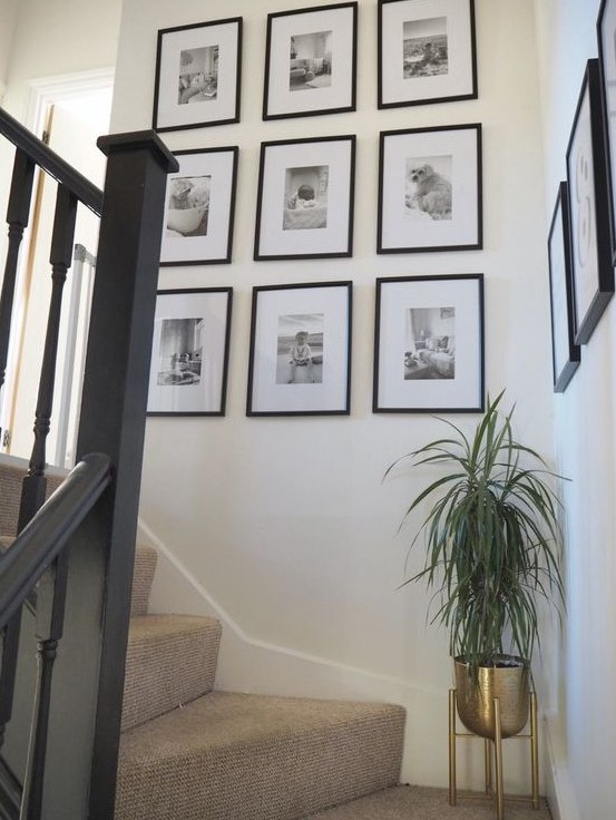 a chic grid gallery wall with matching black frames and black and white photos is a lovely way to display your family pics