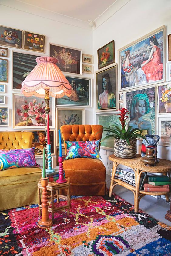 a colorful gallery wall taking two walls, with vintage paintings in neutral frames, with portraits and botanicals is amazing
