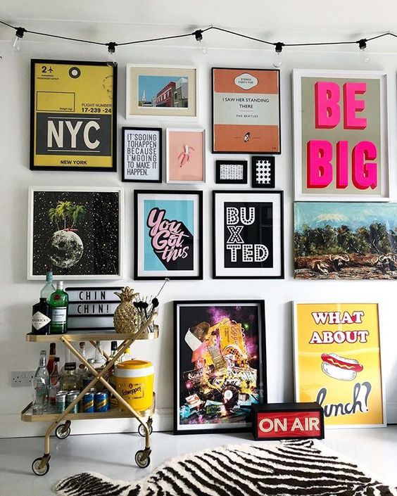 a colorful pop art gallery wall in various colors – posters for fun and with black and white frames is a bold idea