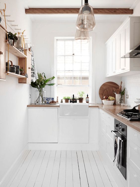 a cool L-shaped Scandinavian kitchen with butcherblock countertops, open shelves and wooden beams