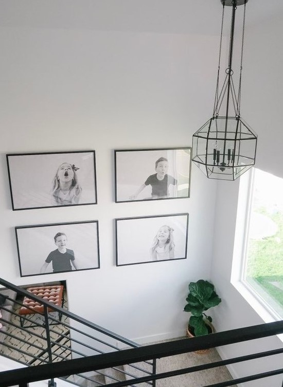 a cool black and white grid gallery wall with black frames shows off kids' pics and adds fun and coziness to the space
