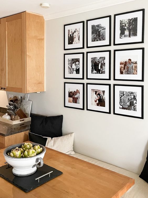 a cool grid gallery wall with family pics in black frames is timeless classics for any home, it will bring memories each time you look at it