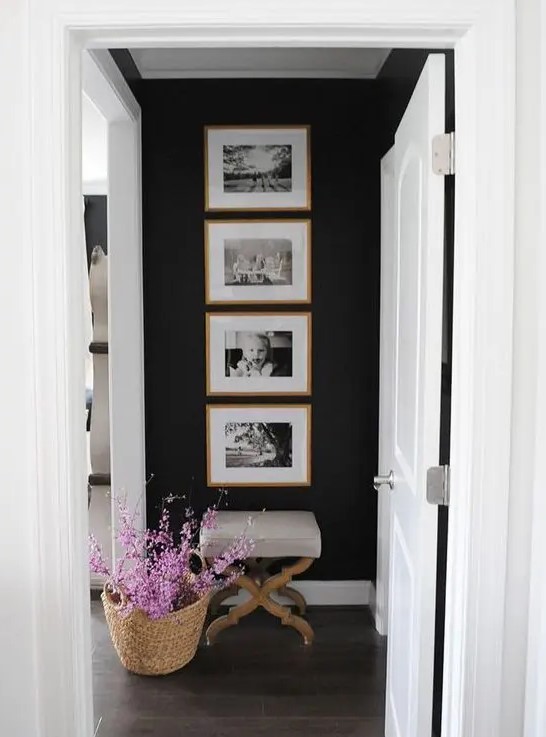 a cool one row grid gallery wall with stained wooden frames and black and white family pics - the shape gives the gallery wlal a modern look