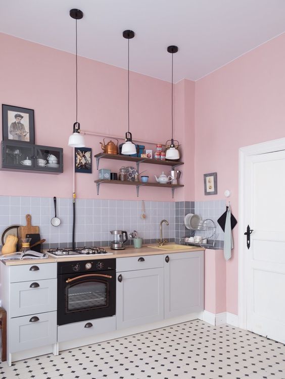 a cozy and cute grey one wall kitchen with a blonde butcherblock countertop and a grey tile backsplash plus pendant lamps