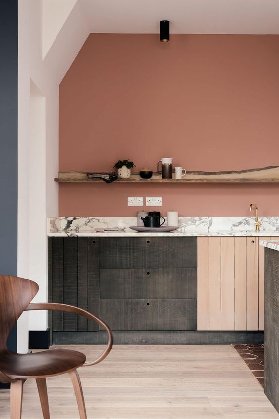 a creatiive mauve kitchen with reclaimed wooden cabinets, a stone countertop and a rough wood shelf