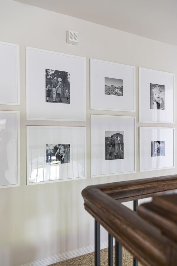 a creative grid gallery wall composed of smaller and larger frames but done in the same height looks very catchy