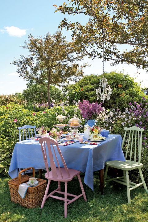 a cute vintage dining area right in the flowers, with a vintage table and matching pastel chairs plus a crystal pendant lamp