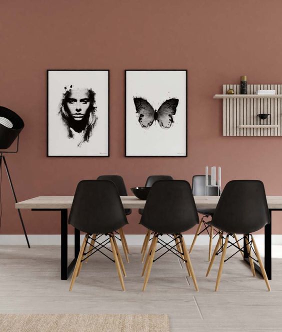 a fabulous mauve dining room with a mauve accent wall, a monochromatic gallery wall and cool chairs and a table