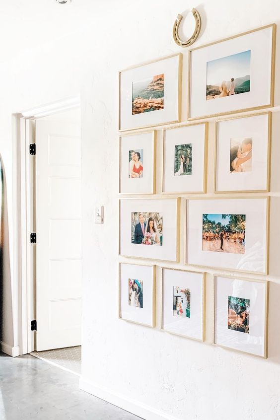 a grid gallery wall but with mismatching frames arranged in rows, with thin blonde wood frames and much matting