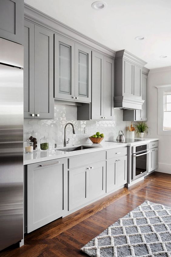 a light grey kitchen with a cool hex tile backsplash and stainless steel appliances is a chic and pretty idea