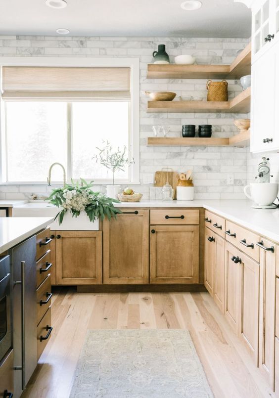 a light-stained wooden kitchen with a marble tile backsplash and open floating shelves is a pretty rustic space