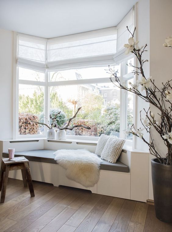 a lovely bow window with a windowsill daybed with pillows make up a lovely reading nook in the space