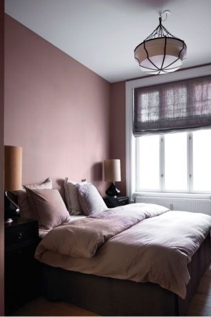 a mauve bedroom with pink bedding, mismatching lamps, purple shades and catchy pendant lamp