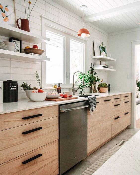 a mid century modern blonde wood kitchen with open shelves, black handles and a skinny tile backsplash