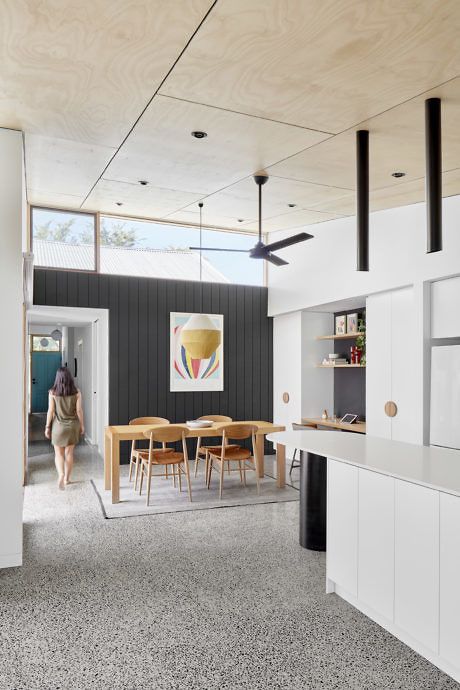 a mid-century modern kitchen and dining zone with chic furniture, clerestory windows for more light and cool pendant lights