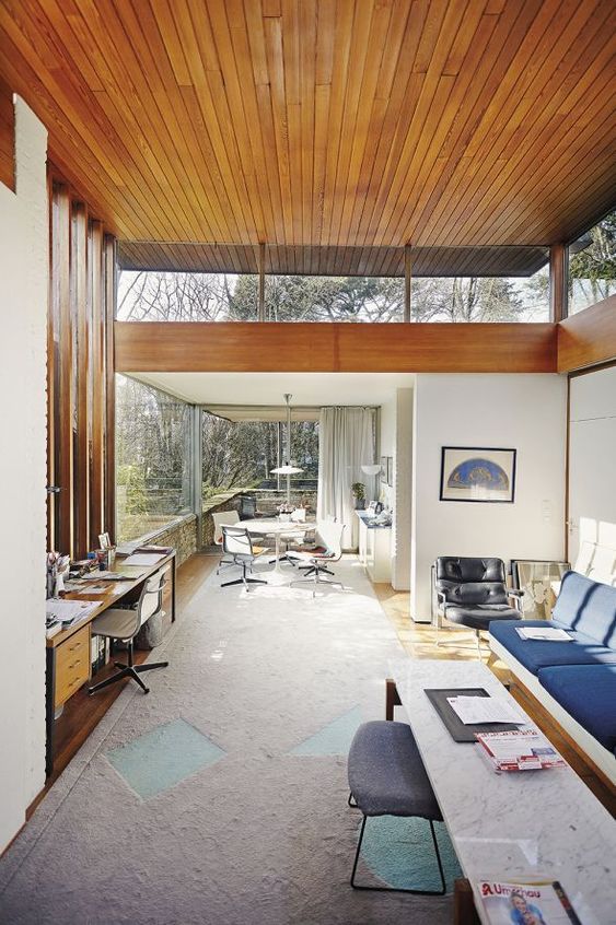 a mid-century modern space with colroful furniture, glazed walls and clerestory windows plus a wood clad ceiling