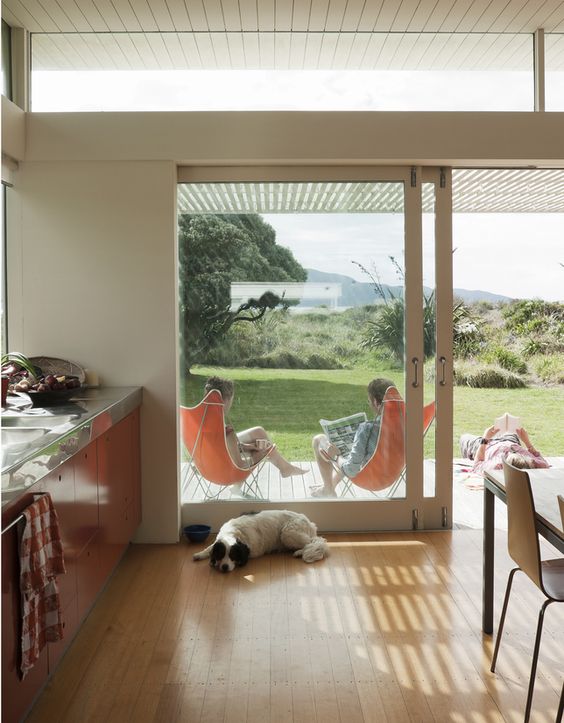 a modern eat-in kitchen with glass sliding doors and clerestory windows that bring more light inside and make it cozier