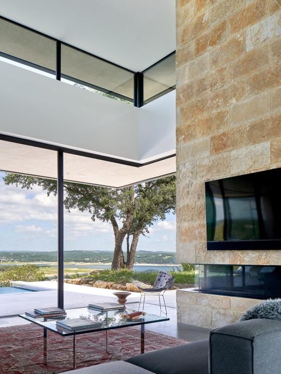 a modern living room with glazed walls to enjoy the views and clerestory windows that bring more light here
