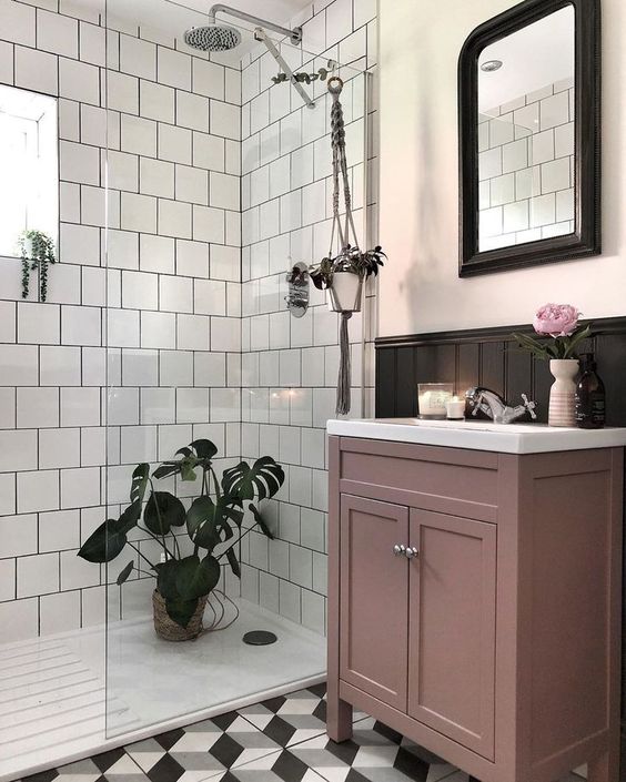 a monochromatic black and white bathroom accented with a mauve vanity looks refined