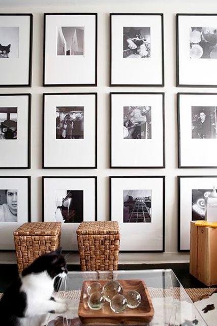 a refined grid gallery wall with thin black frames, much matting and photos placed in the top part of the frame