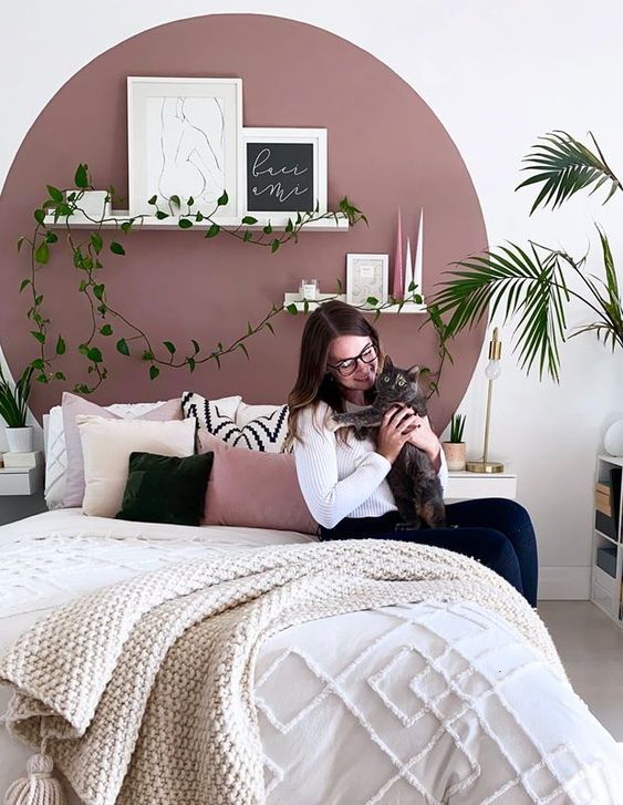 a small and pretty bedroom with a mauve accent and all neutrals around, gold touches and neutral and pink bedding