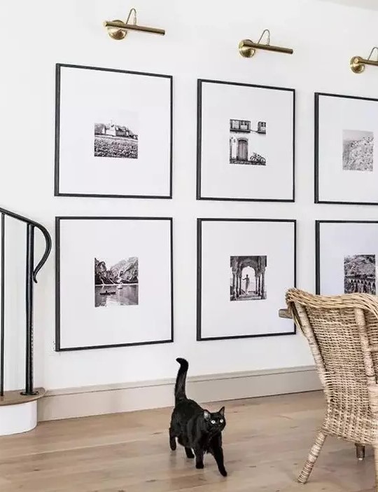 a statement grid gallery wall with matching black frames and black and white artworks with matting is a stylish idea to rock