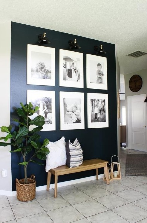 a stylish grid gallery wall with matching white frames and lights to accent it is a cool idea with a modern feel