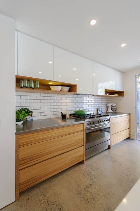 a stylish minimalist kitchen in white and light-stained wood, with a stone countertop and a white subway tile backsplash is wow
