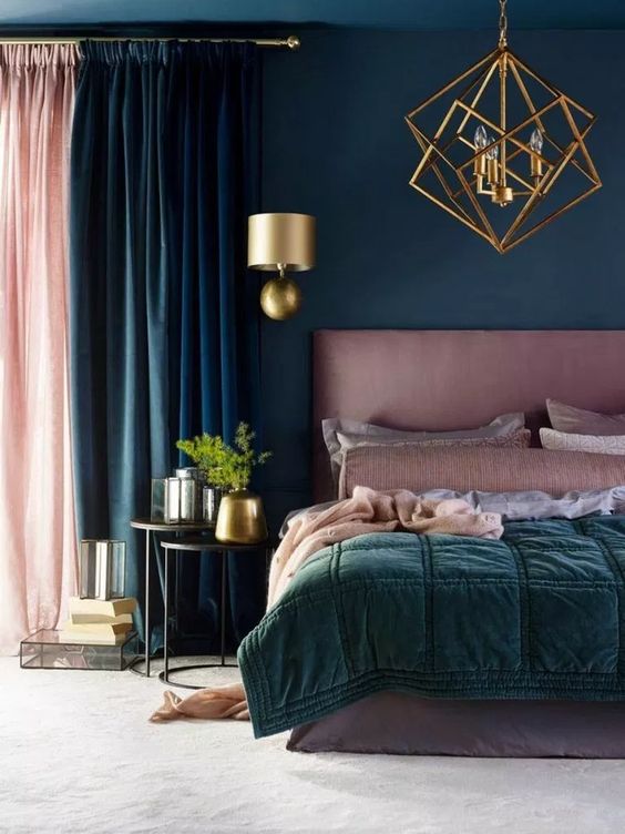 a teal bedroom with a mauve bed, mauve and green bedding, a pink and teal curtain, gold touches for elegance