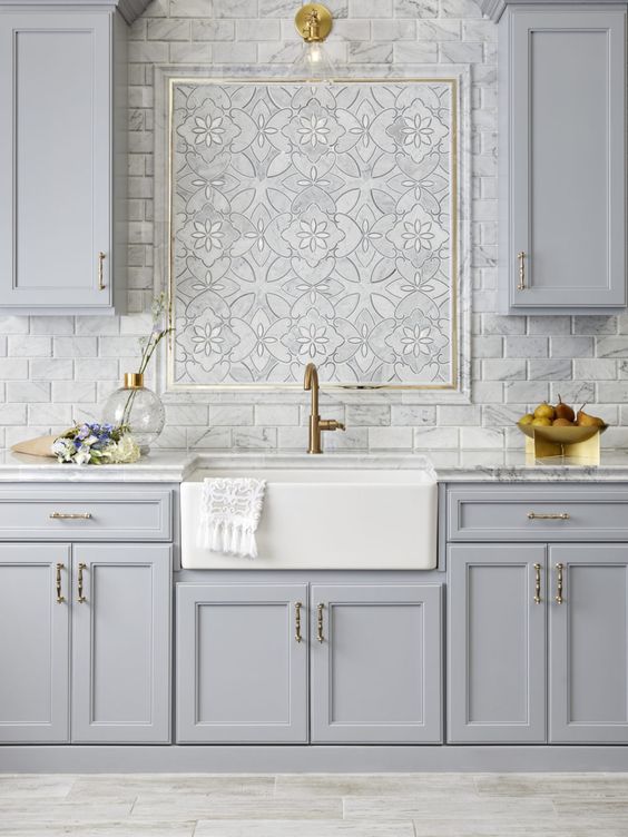 a vintage light grey one wall kitchen with a marble tile backsplash and marble countertops plus a beautiful mosaic in the center