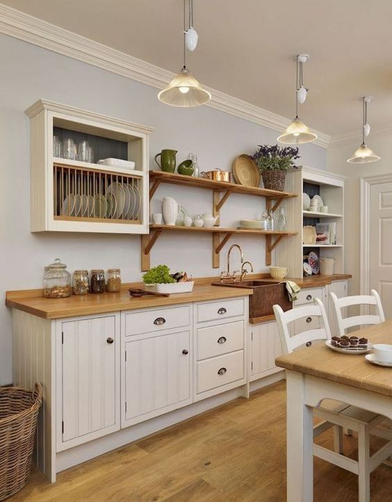 a white one wall farmhouse kitchen with butcherblock countertops, open shelves and box shelves is cozy