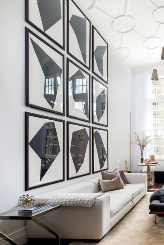 an oversized graphic grid gallery wall takes over the whole space and makes this living room bolder