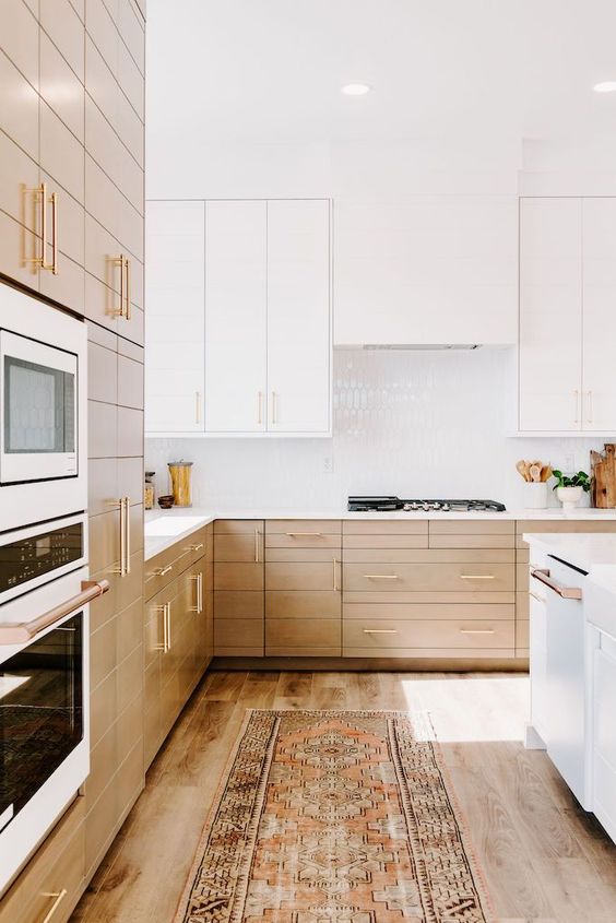 03 a contemporary kitchen with light stained lower cabinets and white upper ones and a seamless hood and white a glossy tile backsplash