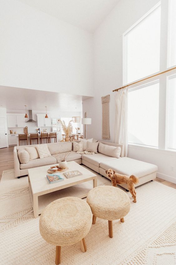 an all-neutral living room with a sectional, a low coffee table, woven stools and neutral textiles is very cool