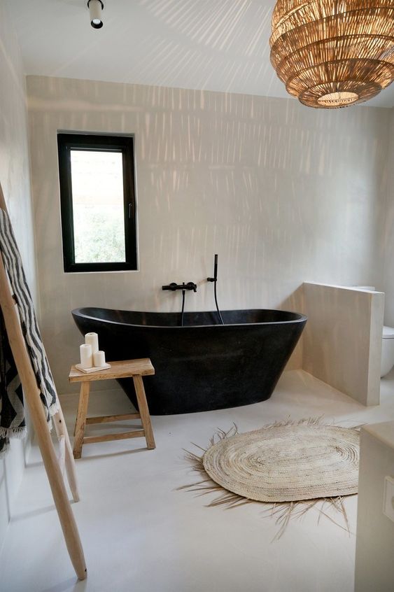 26 a beautiful natural bathroom in neutrals, with a black bathtub and a black framed window, a rattan lamp and a jute rug