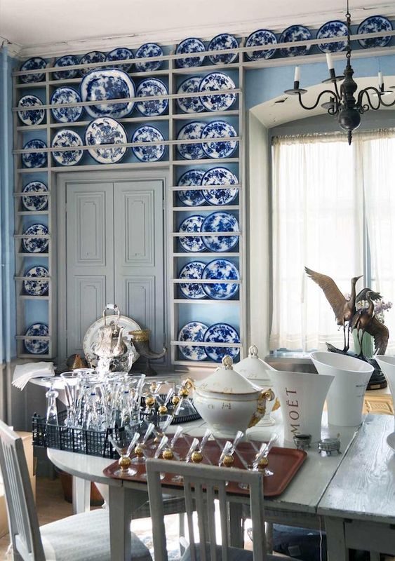 34 a refined dining space with light blue walls, built-in shelves with chinoiserie, neutral vintage furniture and a vintage chandelier