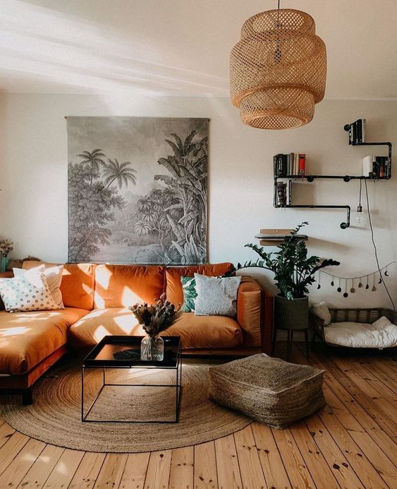 a-boho-living-room-with-an-orange-sectional-a-low-table-a-jute-ottoman-and-a-rug-a-woven-pendant-lamp-and-potted-plants.jpg