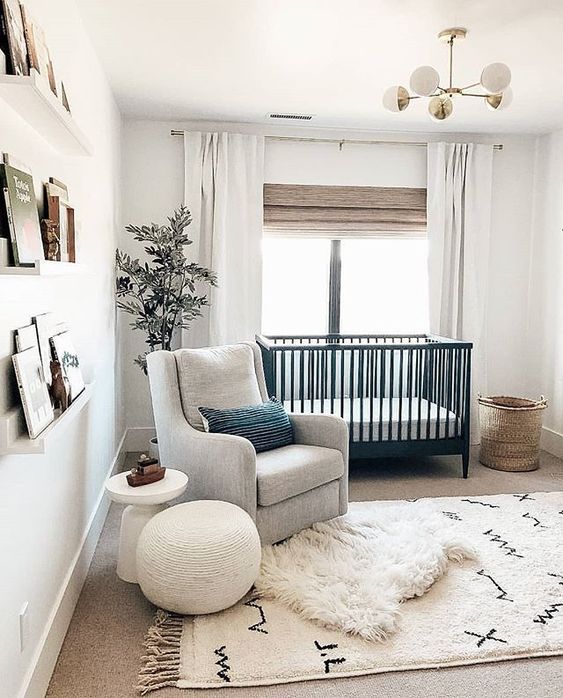 a chic modern nursery with a farmhouse twist, with all-neutrals, a black crib, a basket for storage and ledges with books