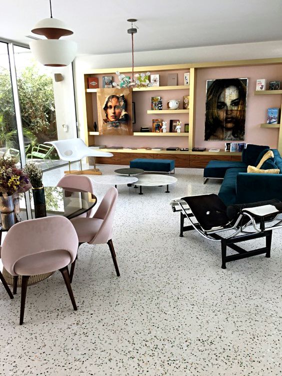 a refined living room with a white terrazzo floor, a pink wall, built in shelves and chic modern furniture