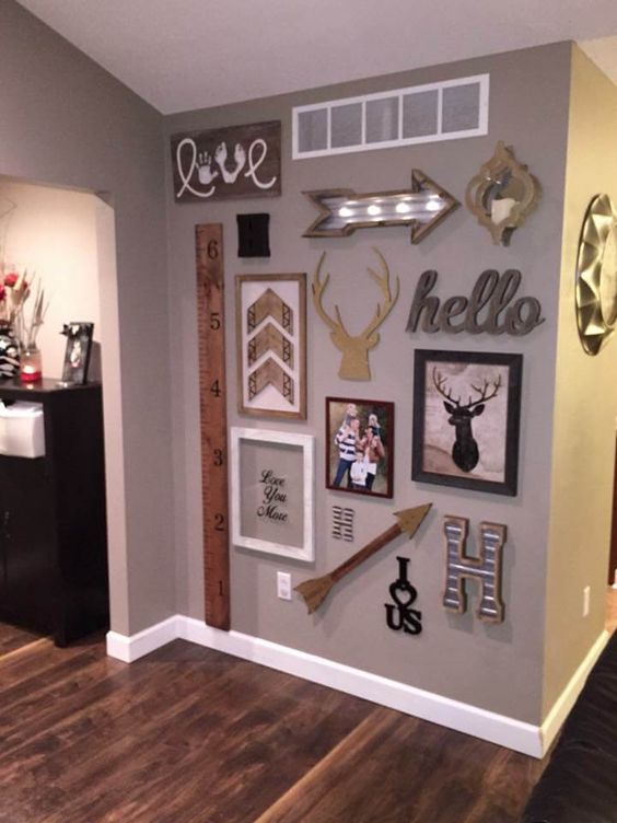 a fun rustic gallery wall with arrows, artworks, photos, signs and monograms looks pretty and very cool
