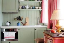 a lovely maximalist kitchen with olive green walls and a kitchen, a red dresser, a refined stool, pink curtains and a bright rug