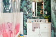 a maximalist bathroom with tropical leaf walls, a pink bathtub, a color block curtain, white furniture and neutral textiles