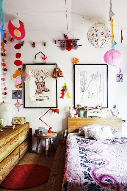 a maximalist bedroom with wooden furniture, bright lamps and artworks, bold bedding for much fun