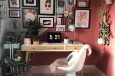 a maximalist home office with a color block wall and ceiling, a desk and a sculptural chair, a gallery wall and potted plants