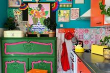 a maximalist kitchen with teal walls, red cabinets, a green dresser, a colorful gallery wall and a checked floor