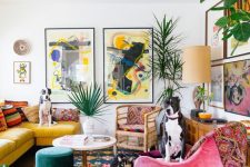 a maximalist living room with a yellow sofa, a pink chair, a colorful rug, a colorful gallery wall and statement plants