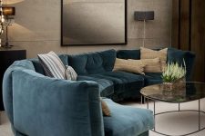 a refined living room with a curved turquoise sofa, a bold chandelier, tan walls with a texture and chic lamps