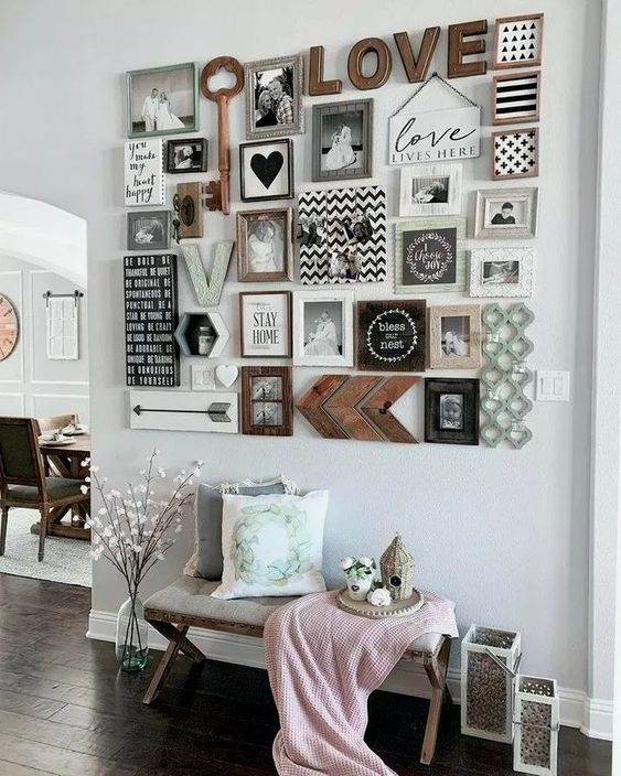 a stylish gallery wall with black and white family pics, wooden keys and signs, hearts and monograms is a lovely idea
