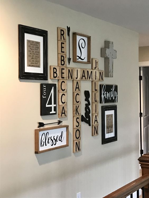a very simple rustic gallery wall with signs in frames, names on wooden plaques, a cross and other stuff is shabby chic