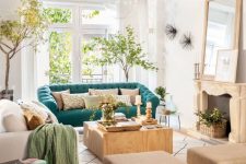 a welcoming living room with a fireplace, neutral furniture, potted trees and a turquoise sofa for a bold color statement